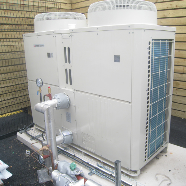 A commercial heat pump system installed in a custom built area.