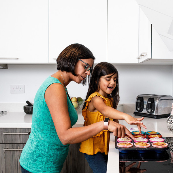 A mother and daugther bake together in an all electric kitchen.