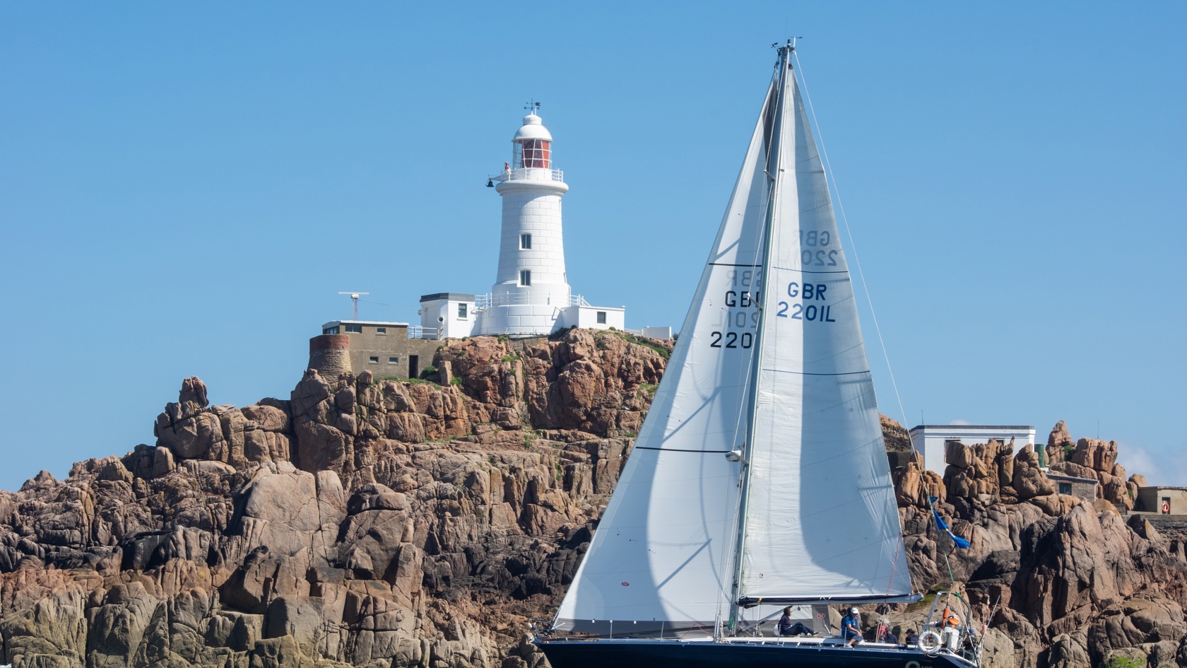 Sailing boat passes Corbiere lighthouse