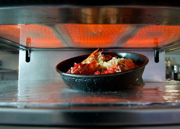 Food cooking under a commercial kitchen grill