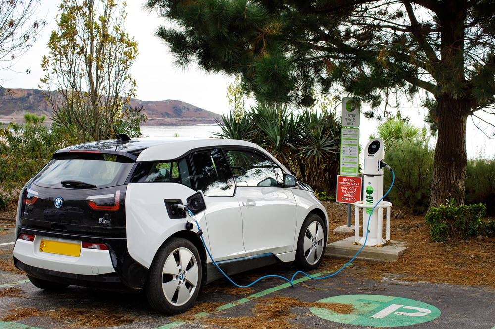 An electric car charges at one of Jersey Electricity's electric car chargers in St Brelade's Bay.