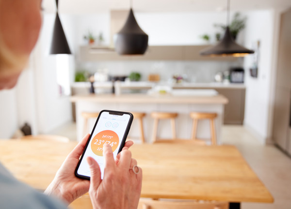 Woman using phone to control her heating