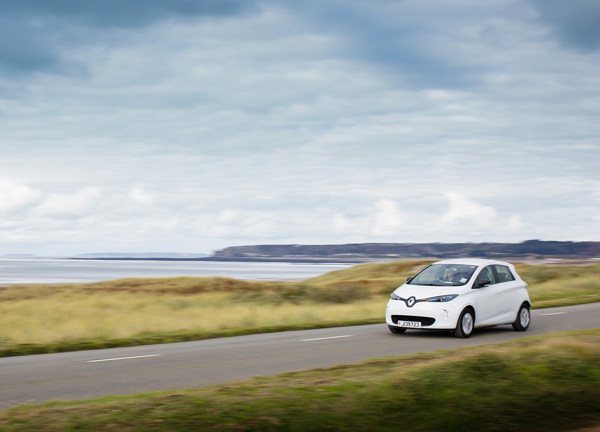 An electric vehicle speeds across the Five Mile Road in St Ouen on a cloudy covered day.