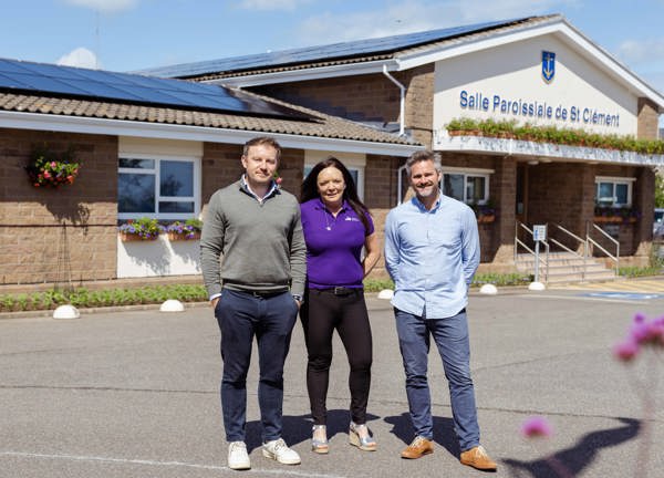 Three people stand outside a building labeled