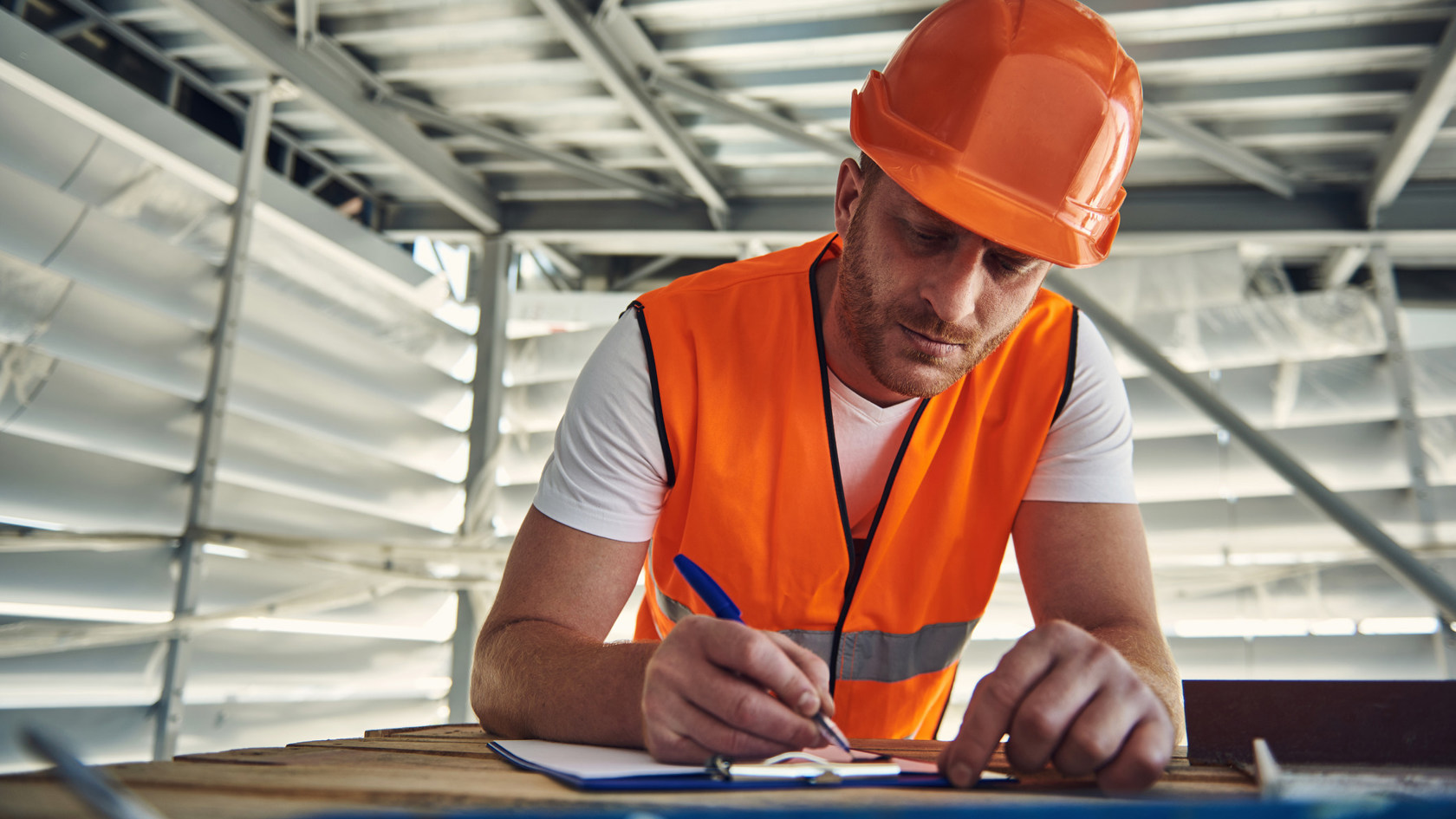 A tradesman completes a form on site.