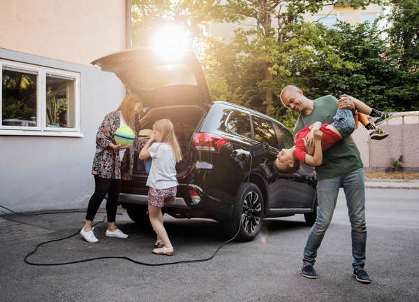 Family of four unpacking an electric car