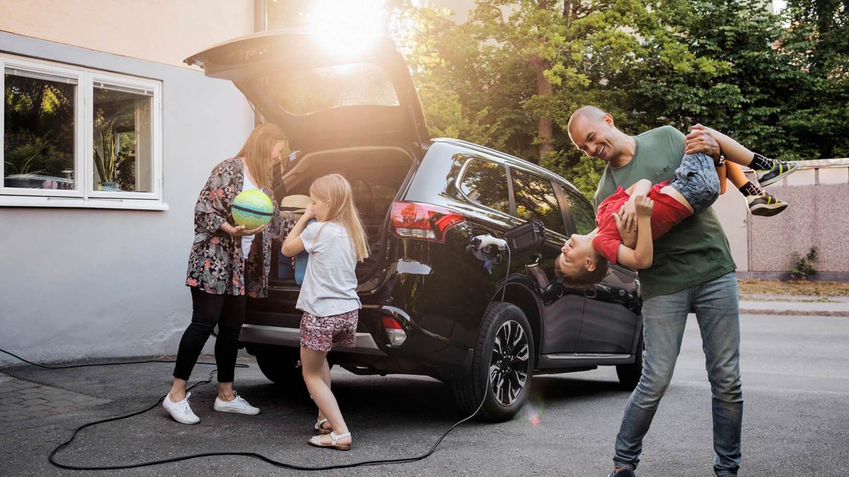 Family of four unpacking an electric car