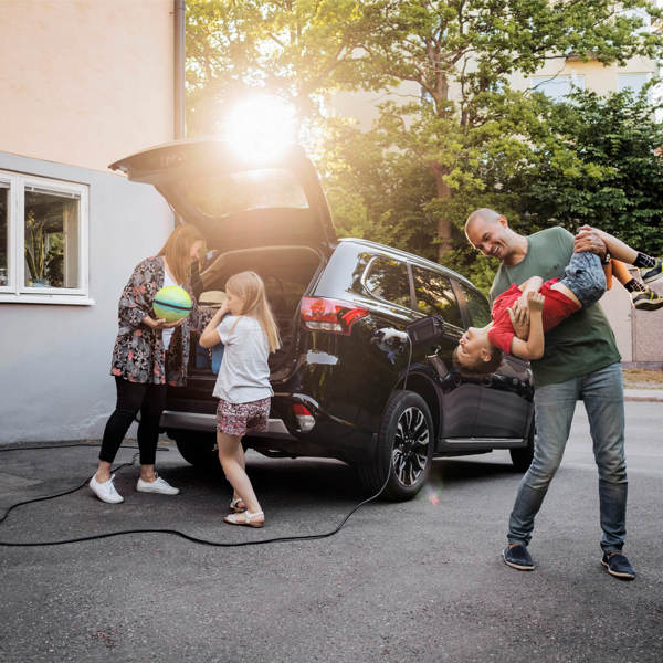 Family of four unpacking an electric car