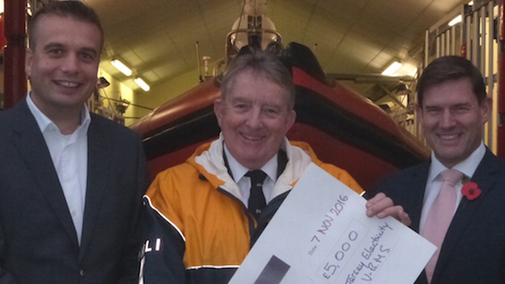 JE & RNLI team members with cheque