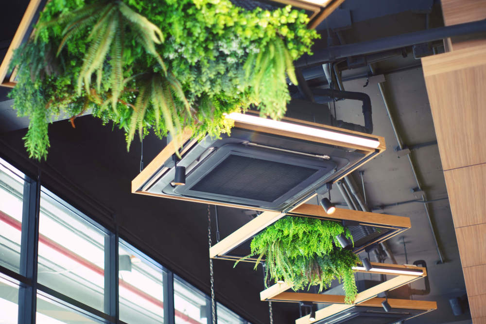 An electric commercial heater unit hangs from the ceiling in a modern cafe.