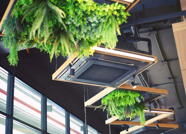 An electric commercial heater unit hangs from the ceiling in a modern cafe.