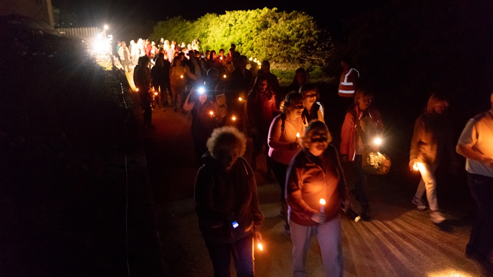 Sanctuary Trust members walking with lanterns at night