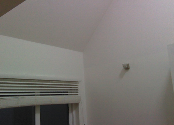 Interior photo of the top of a window and the ceiling above