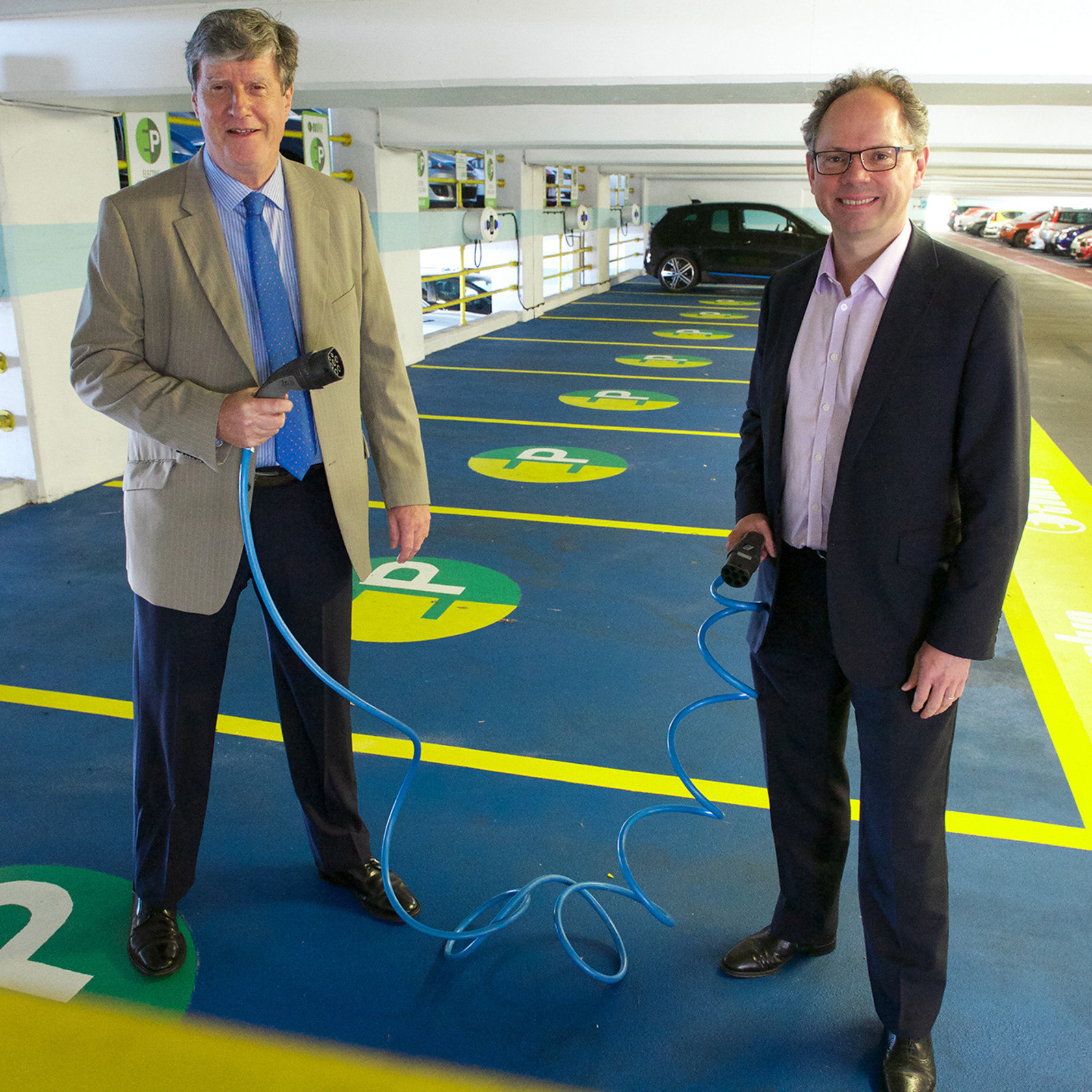 Kevin Pamplin and Chris Amber stand in the electric vehicle charging bays in Pier Road carpark.