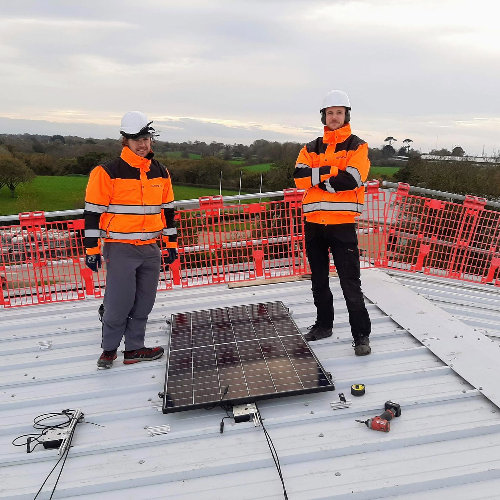 Two members of the Sunworks team begin the Solar PV installation on the roof at Jersey Dairy.