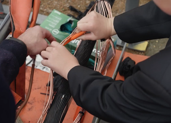 A close up shot of a student being shown how to work on electrical demostration equipment