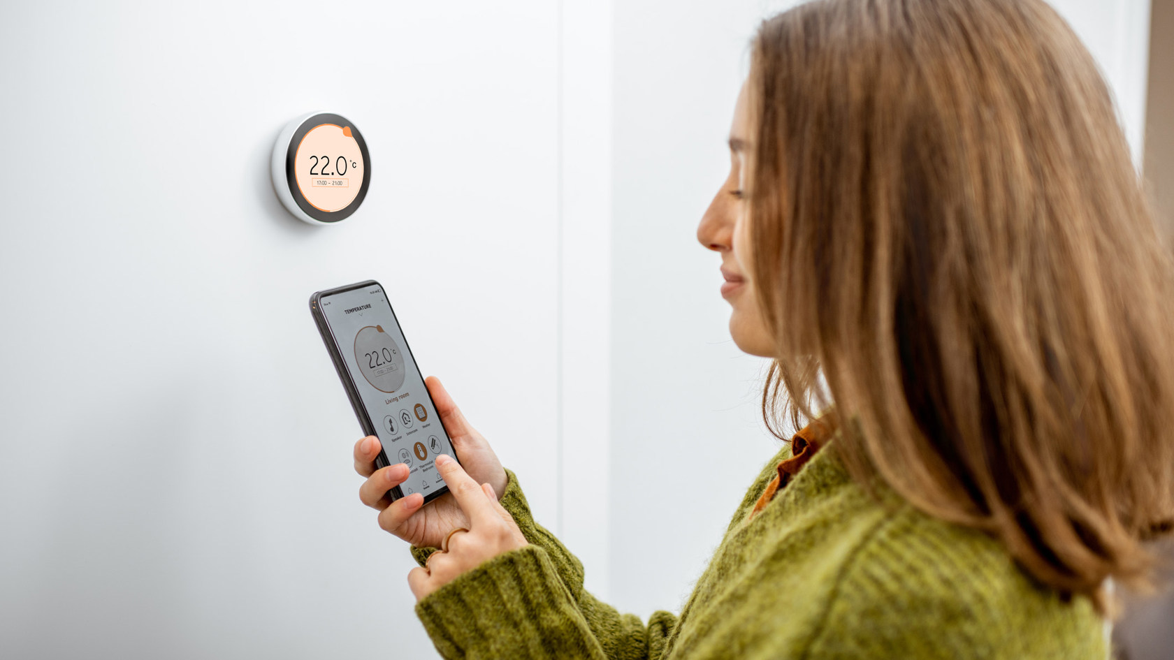 Woman programming heating with smart phone