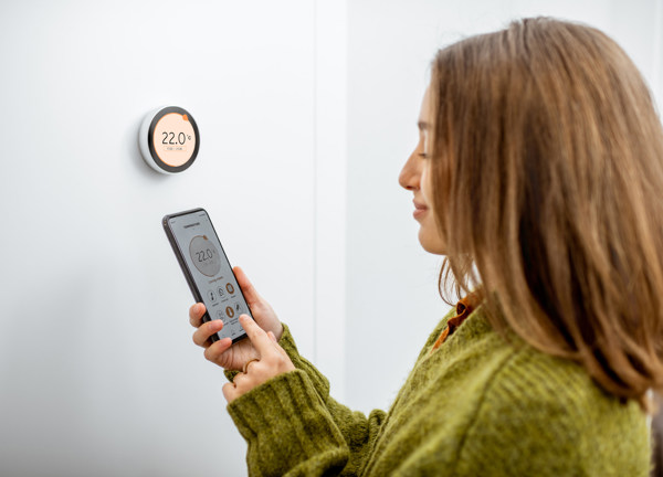 Woman programming heating with smart phone