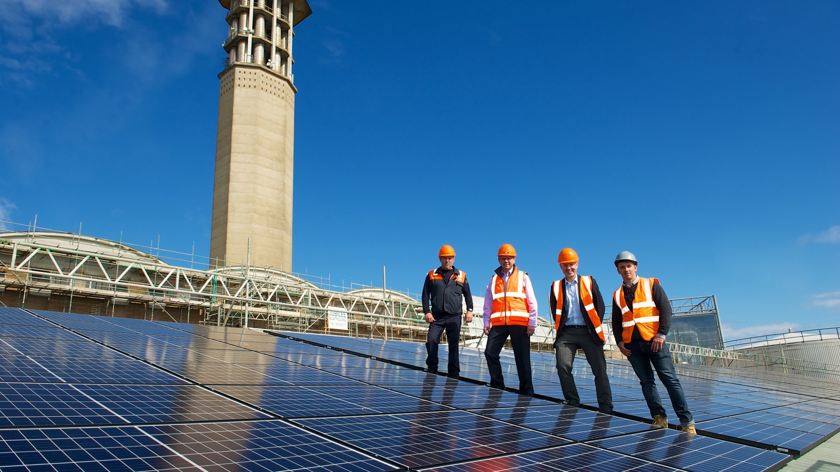 Jersey Electricity and partners stand next to the solar array on La Collette's roof