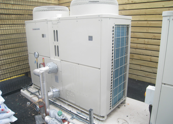 A commercial heat pump system installed in a custom built area.