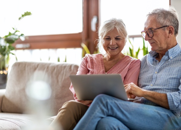 Couple using a laptop on the couch