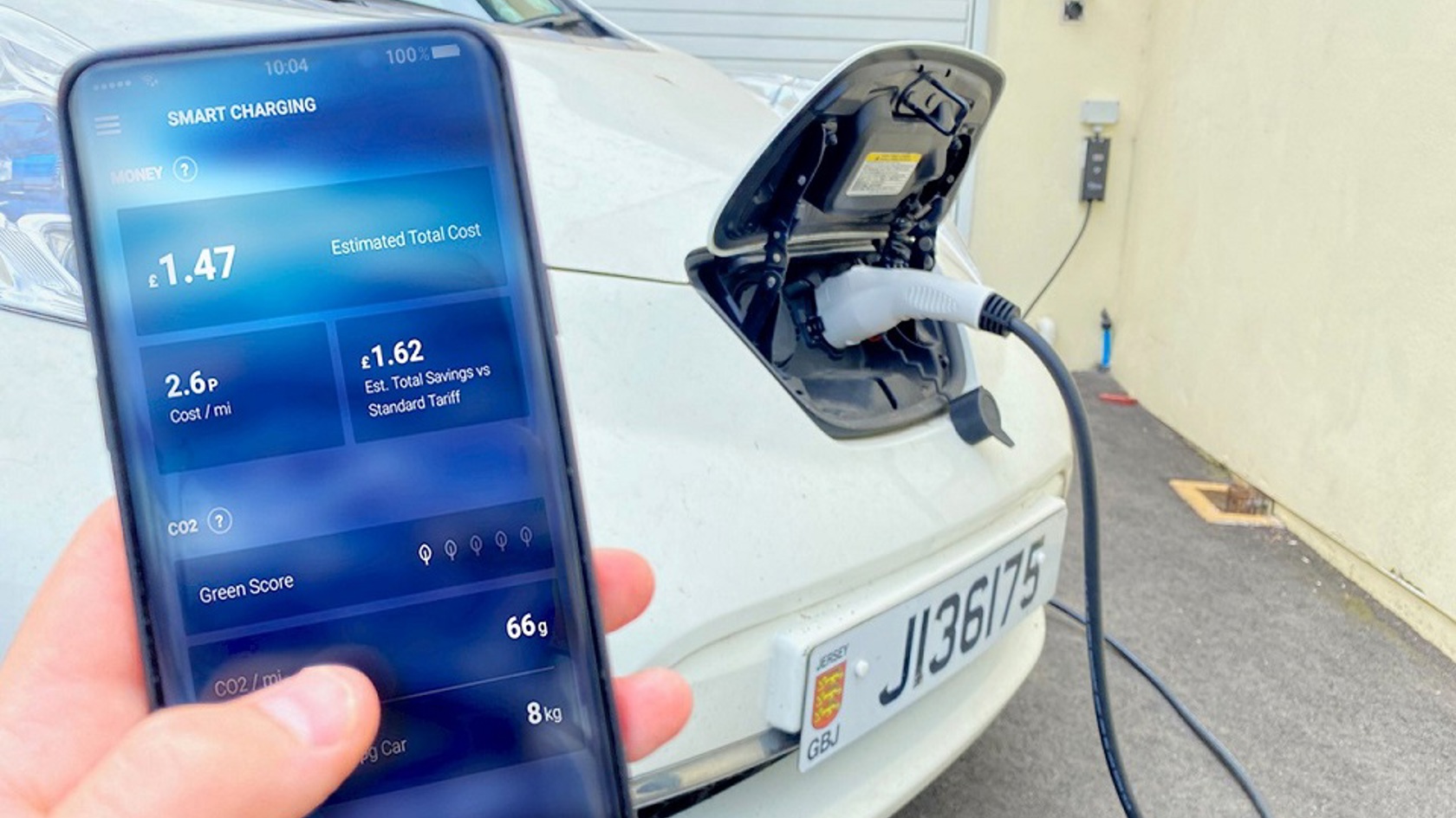 Person monitors electric car charging on smartphone