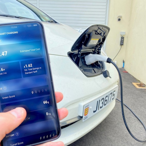 Person monitors electric car charging on smartphone