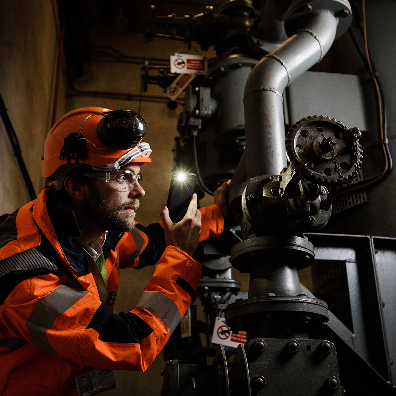 Sam Boleat uses his phone light to inspect a piece of equipment. 