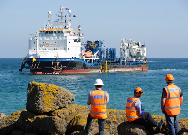 Three members of the Normandie 1 project team watch as Stemat arrives in Jersey.