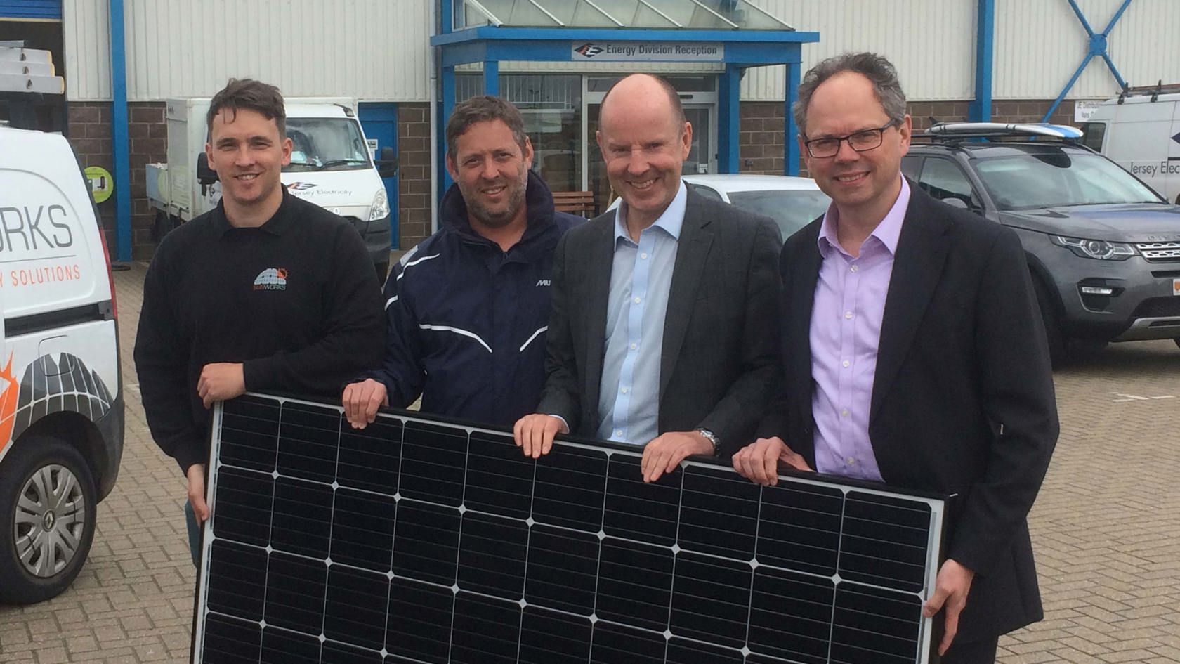 Chris Ambler and solar partners hold a solar panel