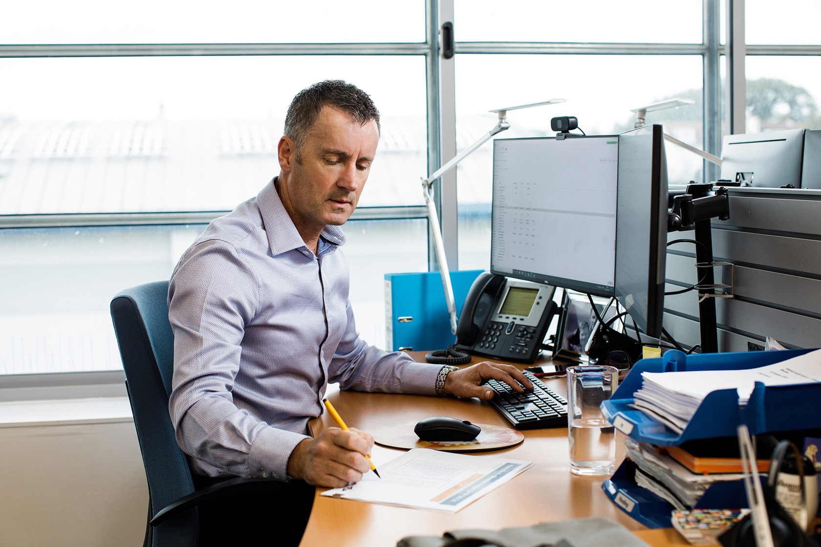 Andy Kemp works at his desk at the Jersey Electricy offices.