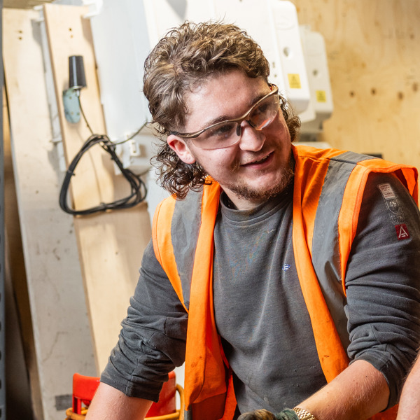 Image of Cody O'Gorman in a workshop wearing safety goggles and a high vis jacket