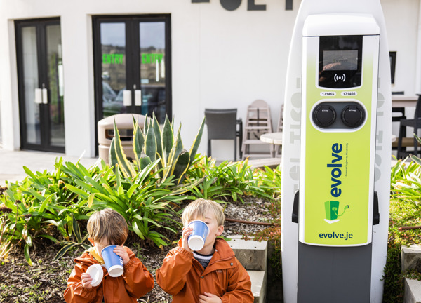 Evolve El Tico charge point with two little boys sitting by enjoying a hot drink