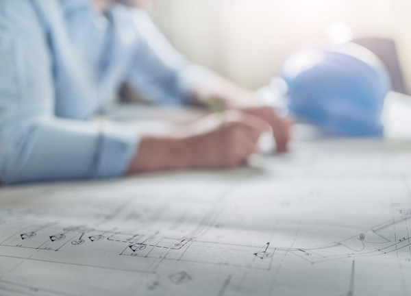 A tradesperson views a set of drawings.