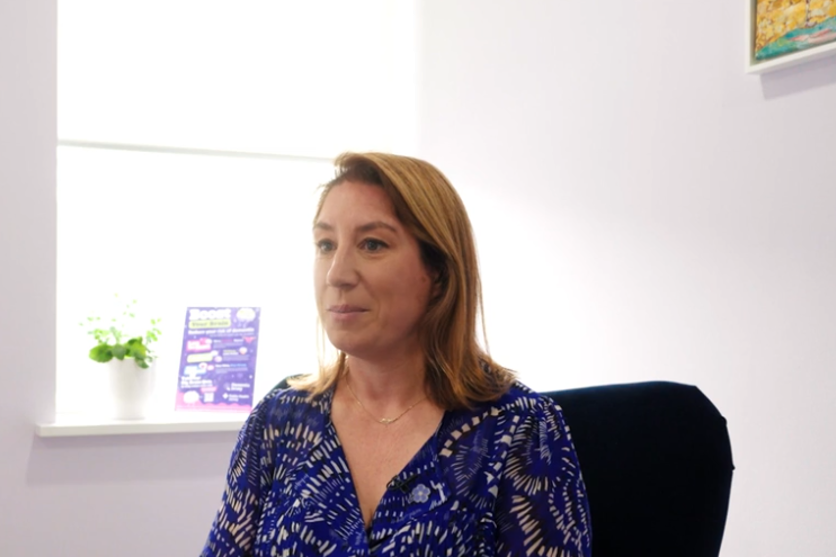 A person in a blue top sat on a chair