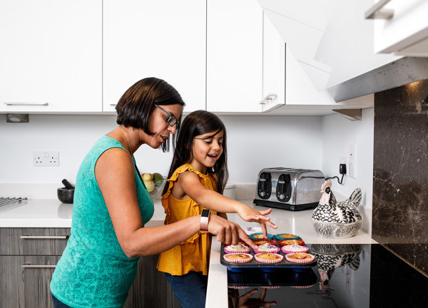 A mother and daugther bake together in an all electric kitchen.