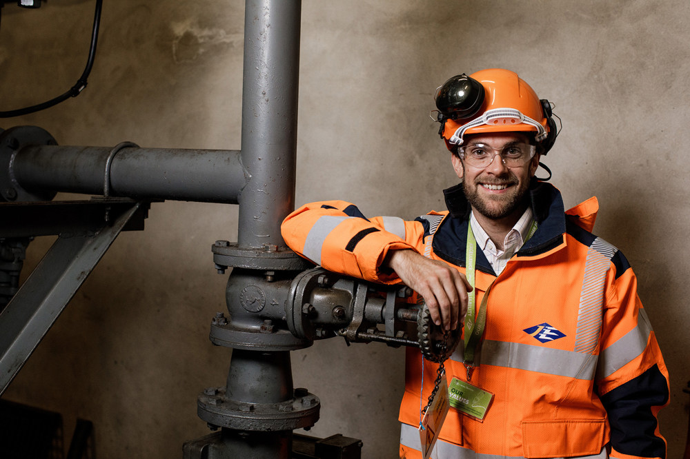 Jersey Electricity engineer, Sam Boleat is pictured next to pipework.