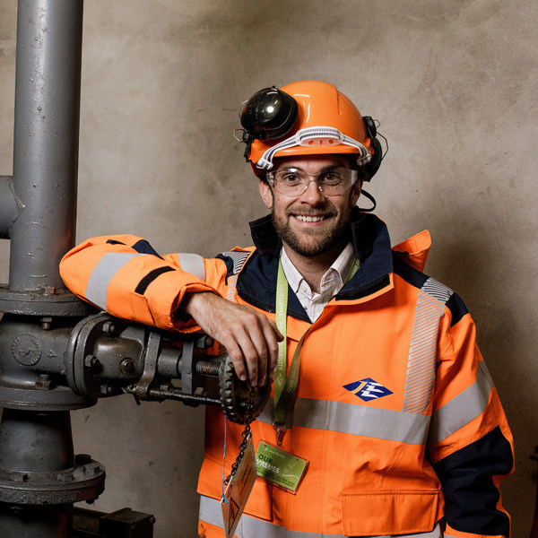 Jersey Electricity engineer, Sam Boleat is pictured next to pipework.