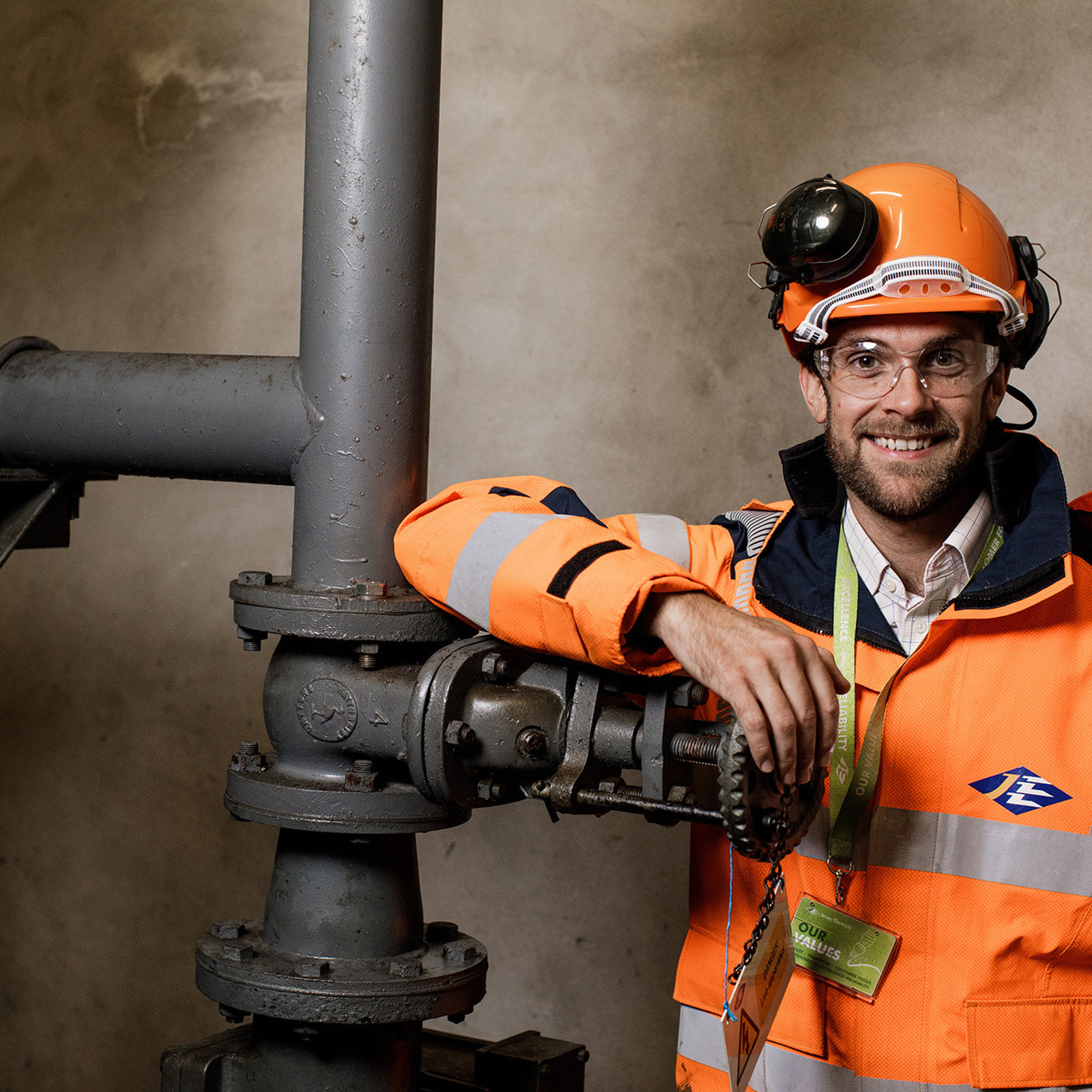 Jersey Electricity engineer, Sam Boleat is pictured next to pipework.