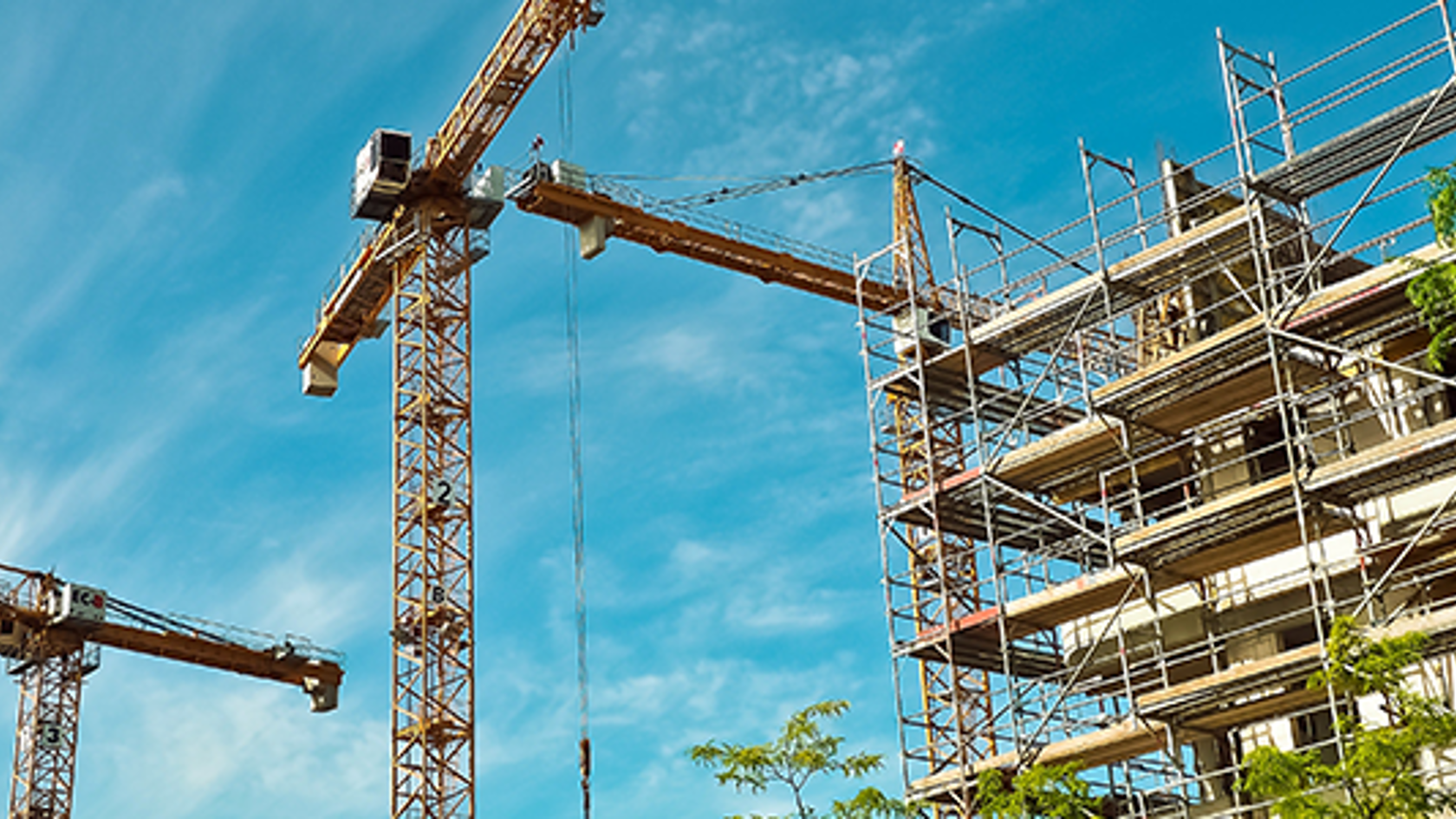 Two cranes working on a building site