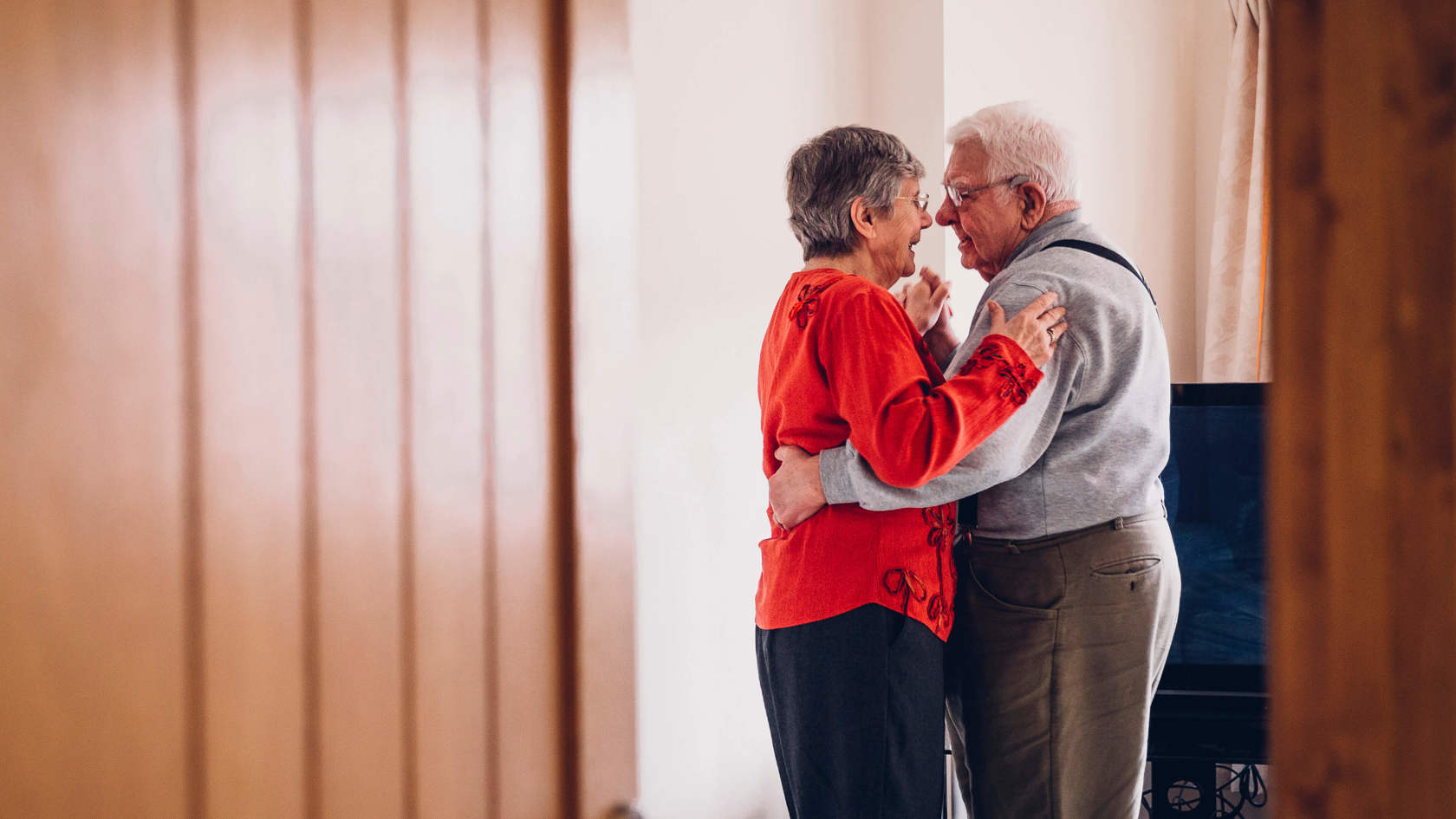 An elderly couple dancing together