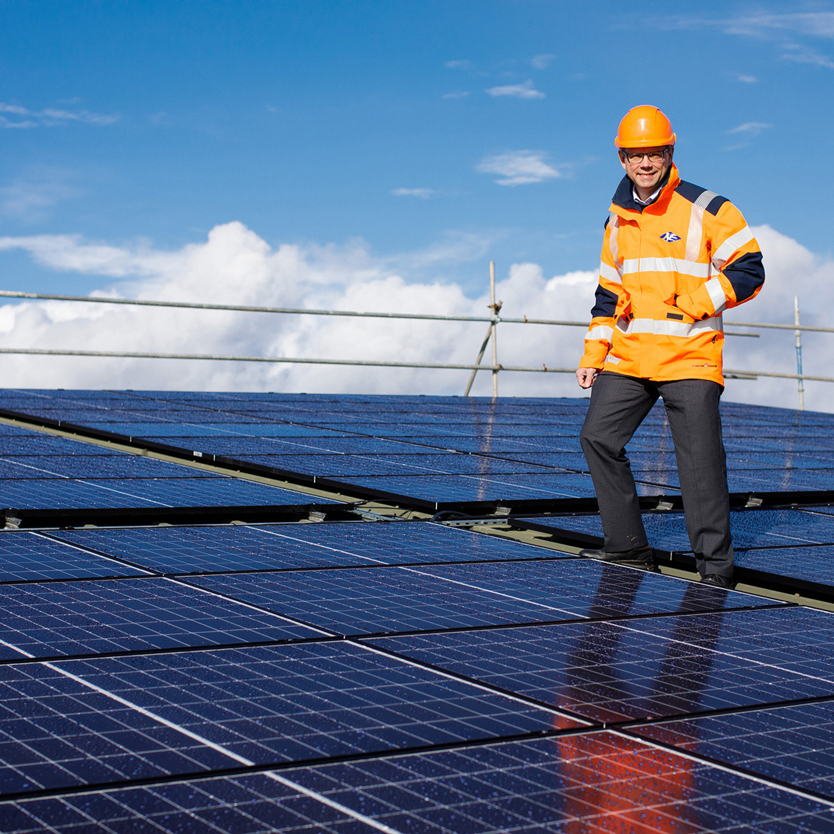 Chris Ambler, Jersey Electricity's Chairman, stands on top of the solar array installed on the roof of the powerhouse.