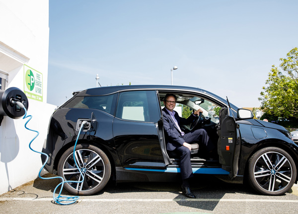 Chris Ambler sits in an electric vehicle whilst it charges at The Powerhouse.