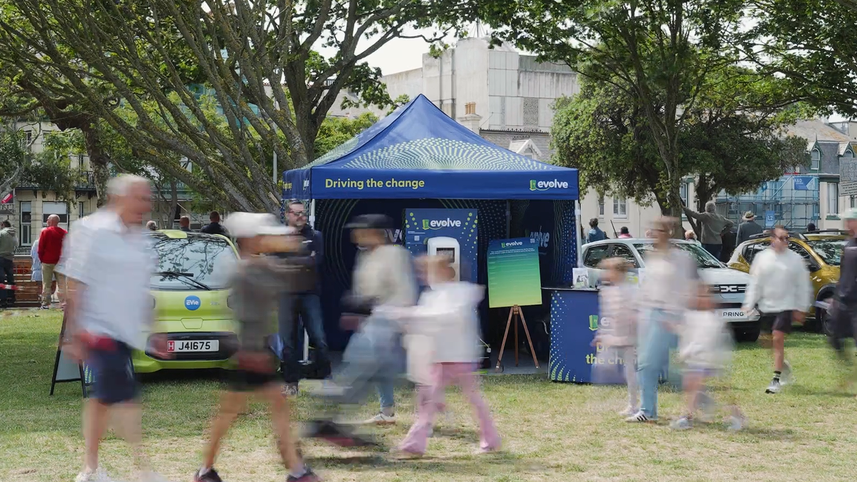 People walking past a blue 